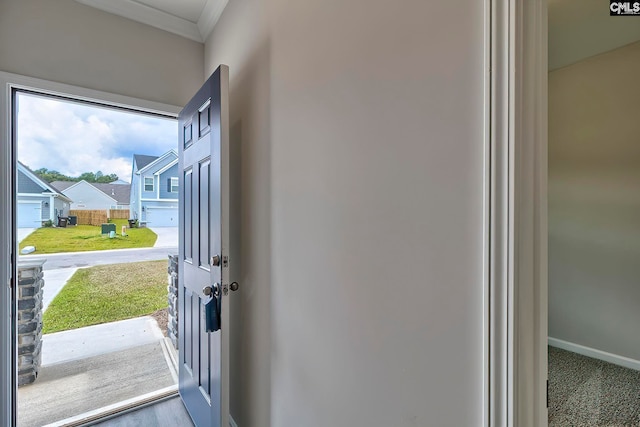 doorway with ornamental molding, a residential view, and baseboards