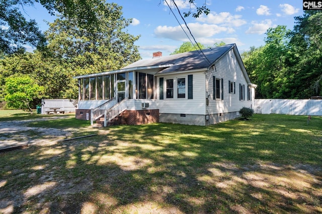 view of front of property featuring a sunroom and a front lawn