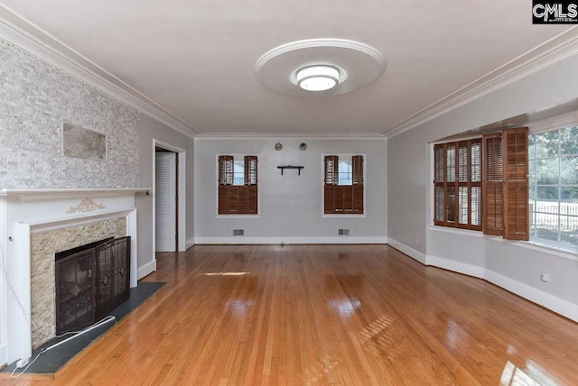 unfurnished living room featuring a high end fireplace, light hardwood / wood-style flooring, and crown molding