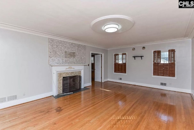 unfurnished living room featuring light hardwood / wood-style flooring, ornamental molding, and a premium fireplace