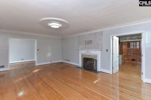 unfurnished living room with light hardwood / wood-style floors and crown molding