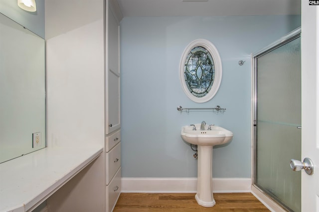 bathroom featuring wood-type flooring and a shower with shower door