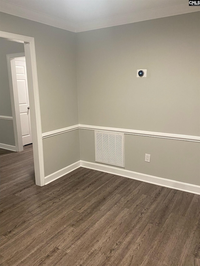 spare room with ornamental molding and dark hardwood / wood-style floors