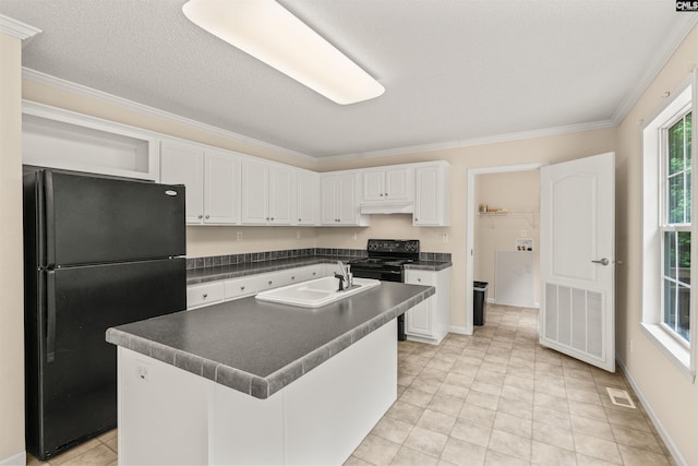 kitchen with dark countertops, black appliances, a kitchen island with sink, and white cabinetry