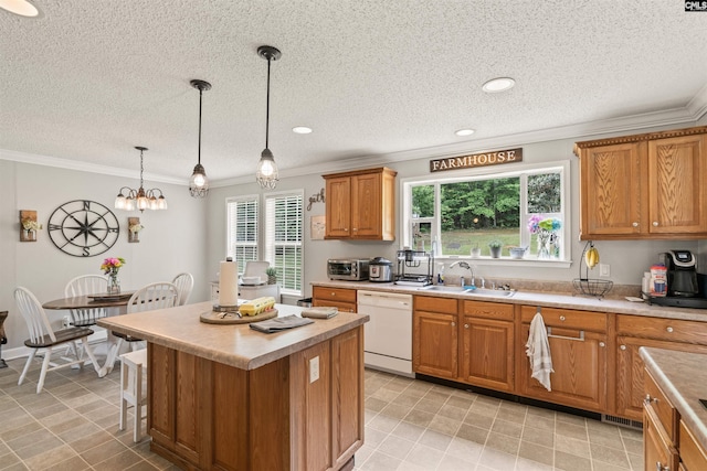 kitchen with white dishwasher, a sink, hanging light fixtures, light countertops, and a center island