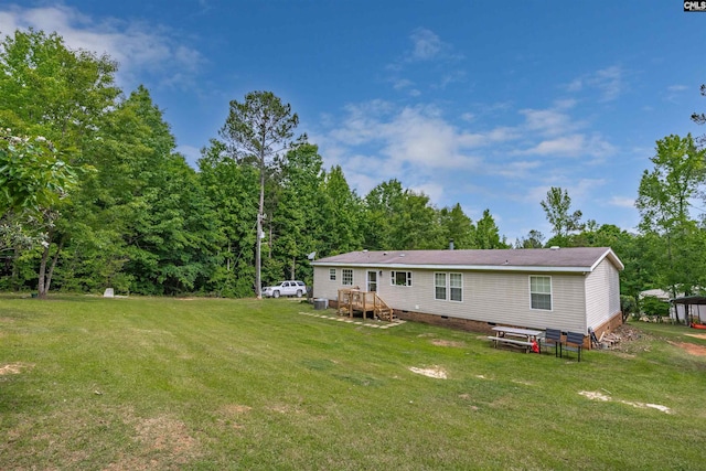 back of property featuring a yard, crawl space, and a wooden deck