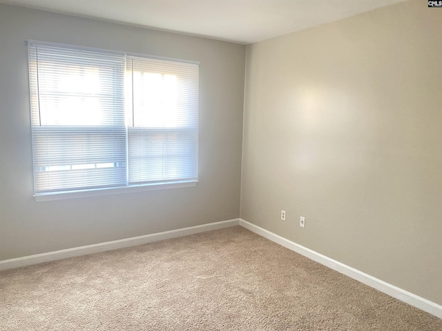 carpeted spare room with baseboards