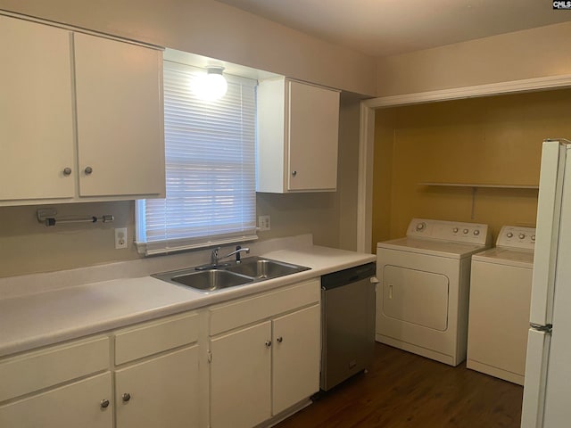 clothes washing area featuring sink, washer and clothes dryer, and dark hardwood / wood-style flooring