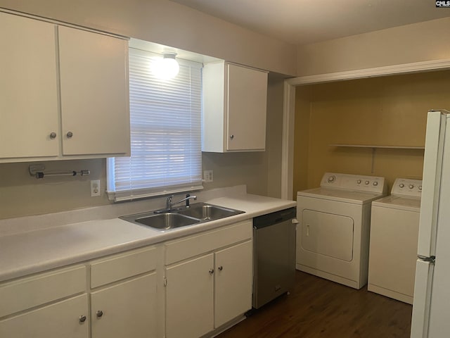 kitchen featuring stainless steel dishwasher, washing machine and dryer, freestanding refrigerator, white cabinetry, and a sink