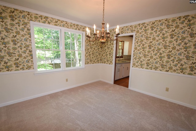 carpeted spare room featuring sink, a notable chandelier, and ornamental molding