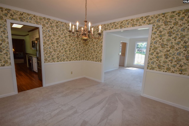 unfurnished room with an inviting chandelier, ornamental molding, and carpet