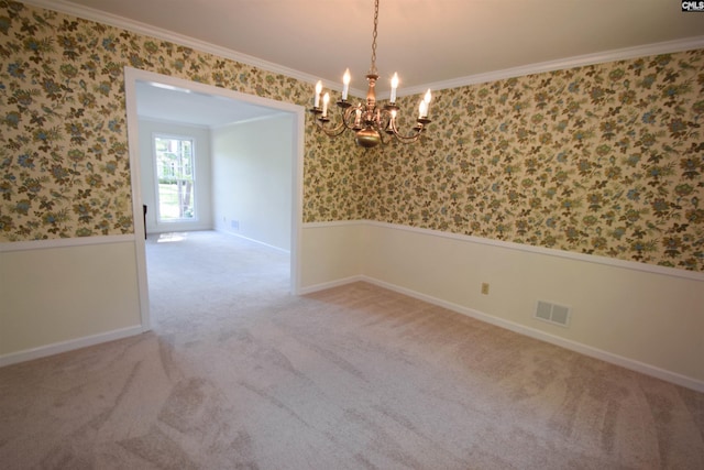 unfurnished room with an inviting chandelier, ornamental molding, and carpet flooring