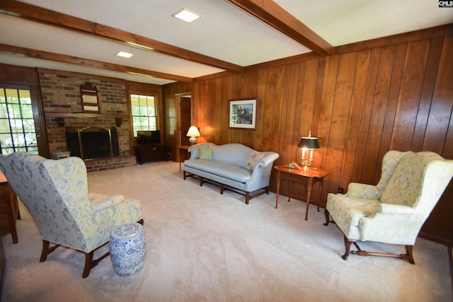 carpeted living room featuring beamed ceiling, wooden walls, a brick fireplace, and a textured ceiling