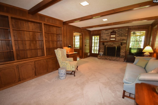 carpeted living room featuring beamed ceiling, a fireplace, and wood walls