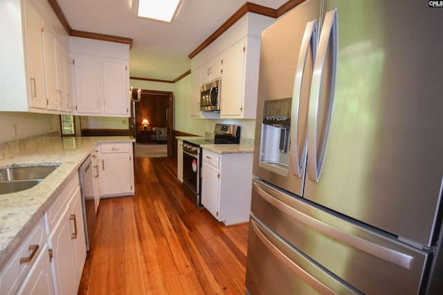 kitchen with stainless steel appliances, white cabinetry, and ornamental molding