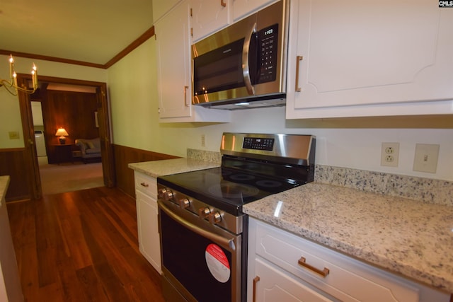 kitchen featuring light stone counters, ornamental molding, appliances with stainless steel finishes, dark hardwood / wood-style flooring, and white cabinets