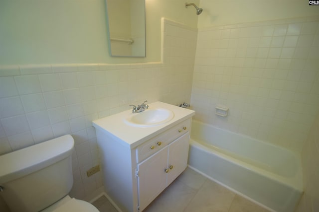 full bathroom featuring tile patterned floors, toilet, tile walls, vanity, and tiled shower / bath combo