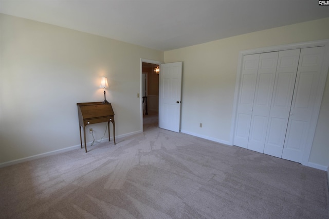 unfurnished bedroom with light colored carpet and a closet