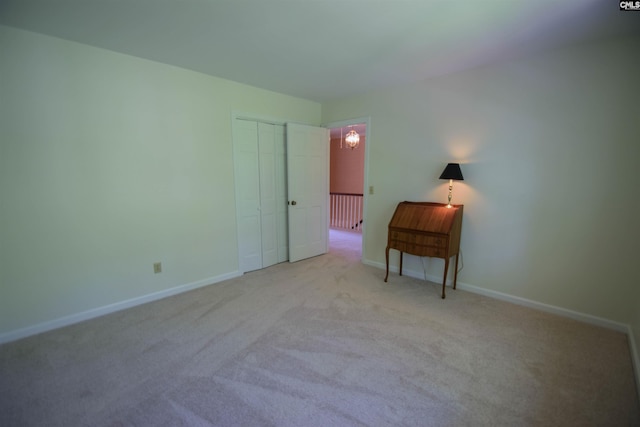 unfurnished bedroom featuring light carpet and a closet