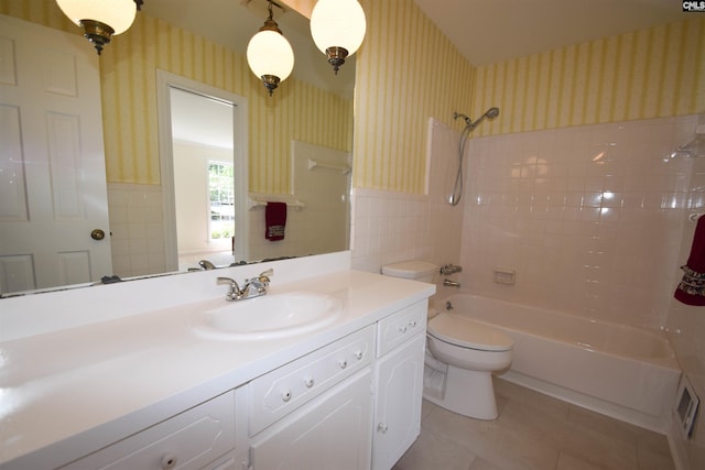 full bathroom with toilet, tiled shower / bath, tile walls, vanity, and tile patterned flooring