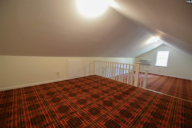 additional living space featuring vaulted ceiling, carpet flooring, and a wall mounted AC