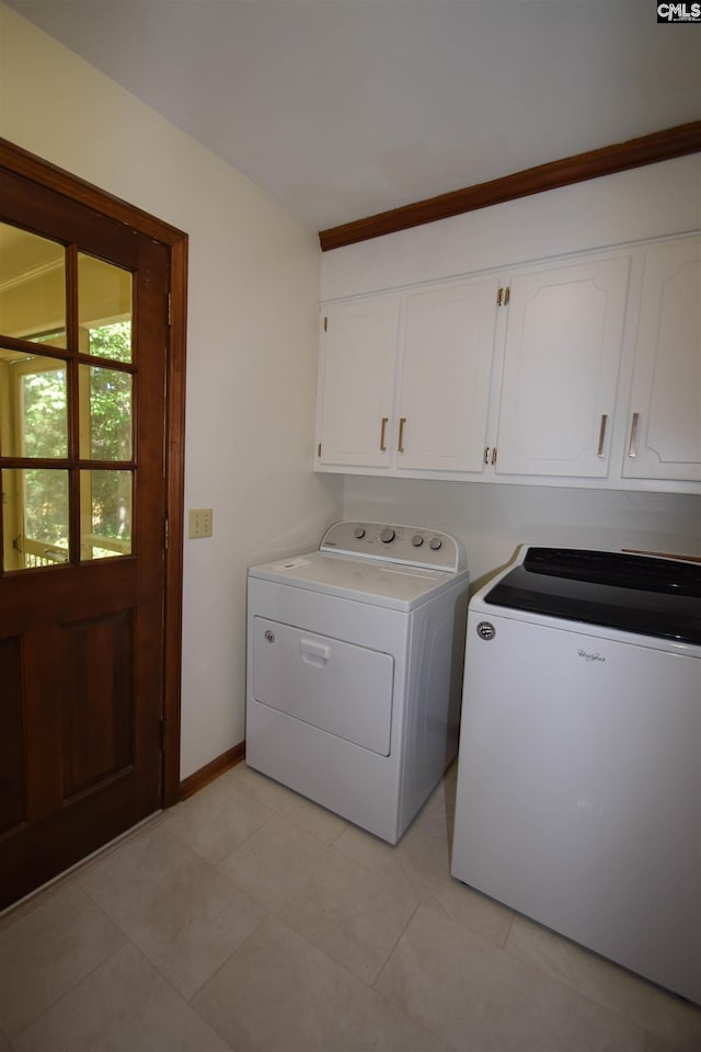 washroom with cabinets, light tile patterned flooring, and independent washer and dryer