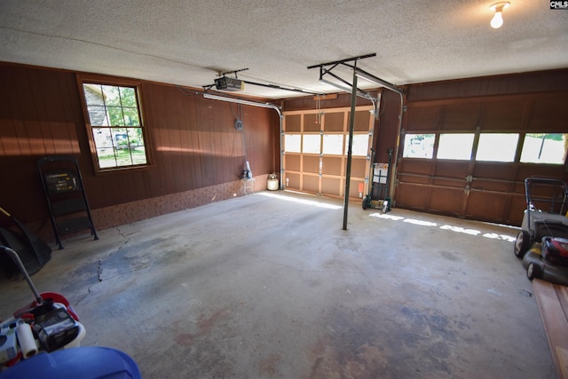 garage with a garage door opener and wooden walls