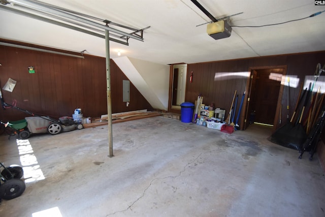 garage with a garage door opener, electric panel, and wood walls