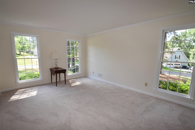 unfurnished room with a wealth of natural light, ornamental molding, and light colored carpet