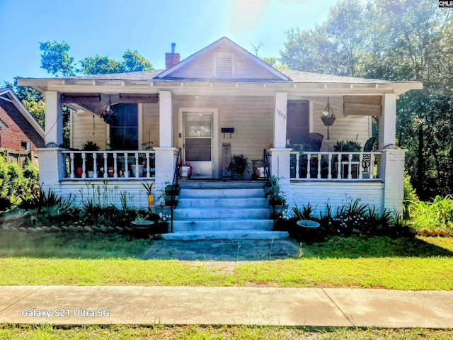 bungalow-style home featuring a porch and a front lawn