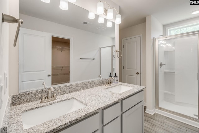 bathroom featuring a shower with door, vanity, and hardwood / wood-style floors