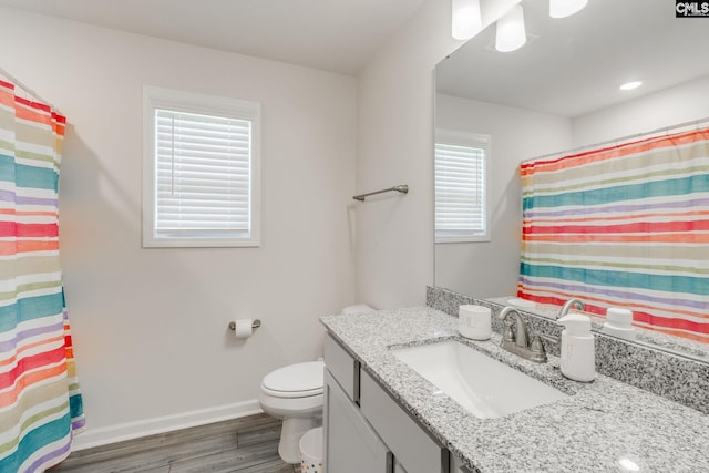 bathroom featuring wood-type flooring, vanity, and toilet