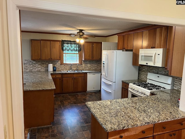 kitchen featuring white appliances, sink, crown molding, ceiling fan, and kitchen peninsula