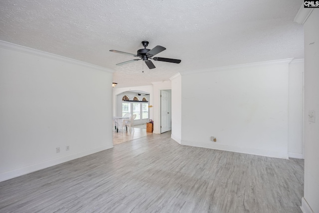 empty room featuring crown molding, ceiling fan, a textured ceiling, and light wood-type flooring