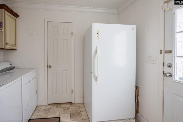 laundry area featuring washer and dryer, light tile flooring, a wealth of natural light, and cabinets