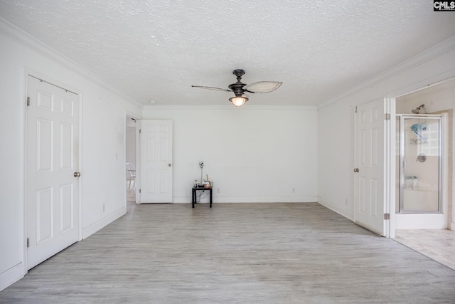 empty room with ceiling fan, a textured ceiling, and crown molding