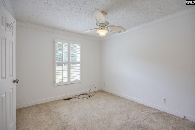 carpeted spare room featuring ceiling fan, a textured ceiling, and crown molding