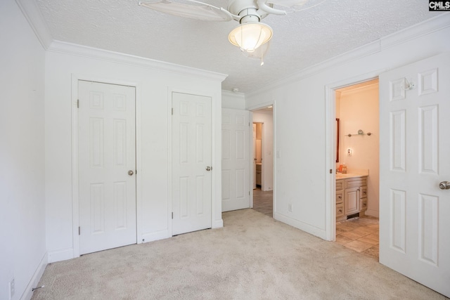 unfurnished bedroom featuring ceiling fan, a textured ceiling, ornamental molding, and light tile floors