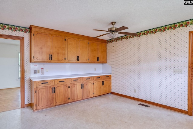 kitchen featuring a textured ceiling, ceiling fan, and light tile floors