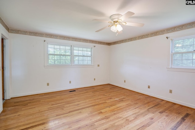 empty room with ceiling fan and light hardwood / wood-style flooring