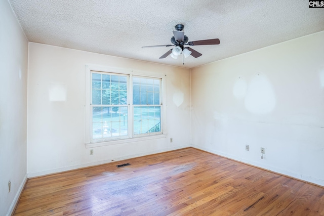 unfurnished room featuring ceiling fan, light hardwood / wood-style floors, and a textured ceiling