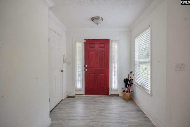 entryway with crown molding, a textured ceiling, and wood-type flooring