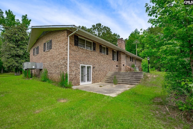 rear view of house featuring french doors and a lawn