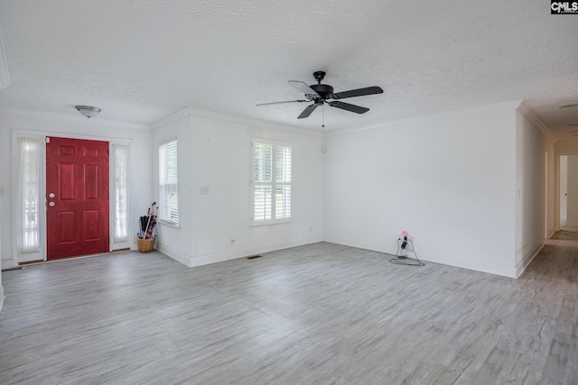 foyer entrance featuring ceiling fan, a textured ceiling, hardwood / wood-style flooring, and ornamental molding