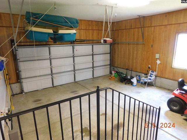 garage with a garage door opener and wooden walls