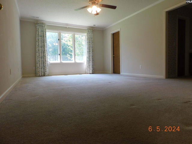 carpeted spare room featuring ceiling fan and crown molding