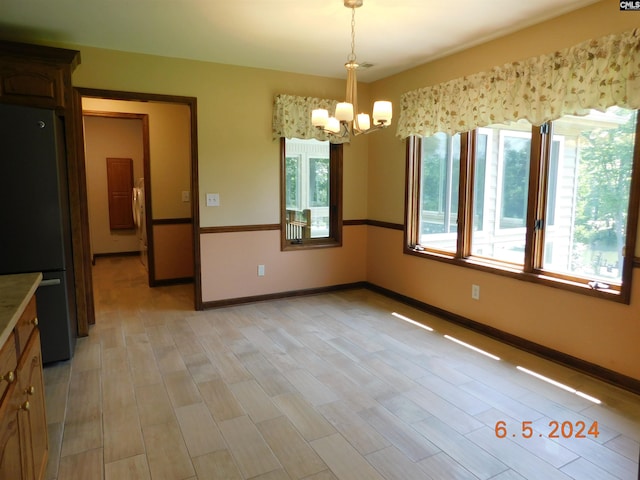 125 Milmont Shores Rd, Chapin, SC 29036 - unfurnished dining area featuring a chandelier, baseboards, and light wood-type flooring