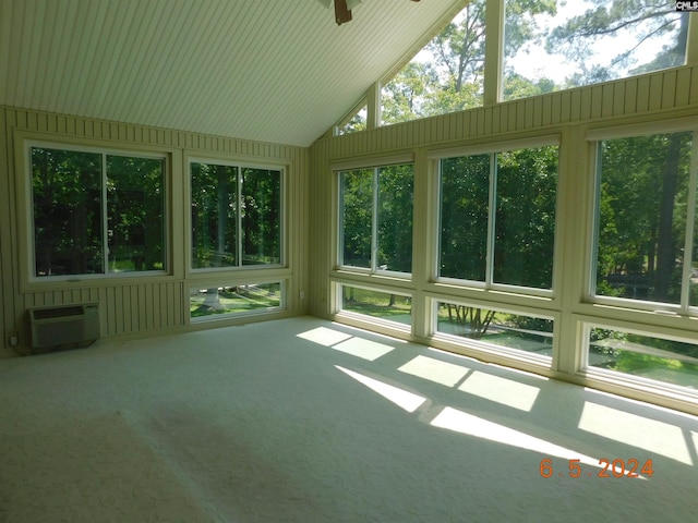 unfurnished sunroom featuring ceiling fan, a healthy amount of sunlight, lofted ceiling, and a wall unit AC