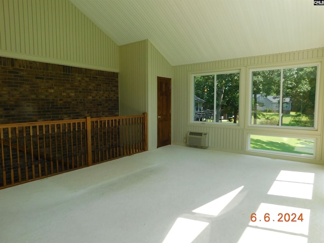 sunroom featuring lofted ceiling and a wall mounted AC