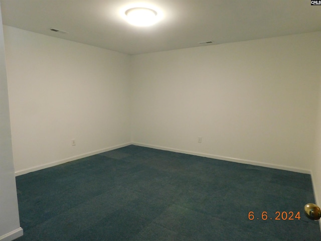 unfurnished room with dark carpet